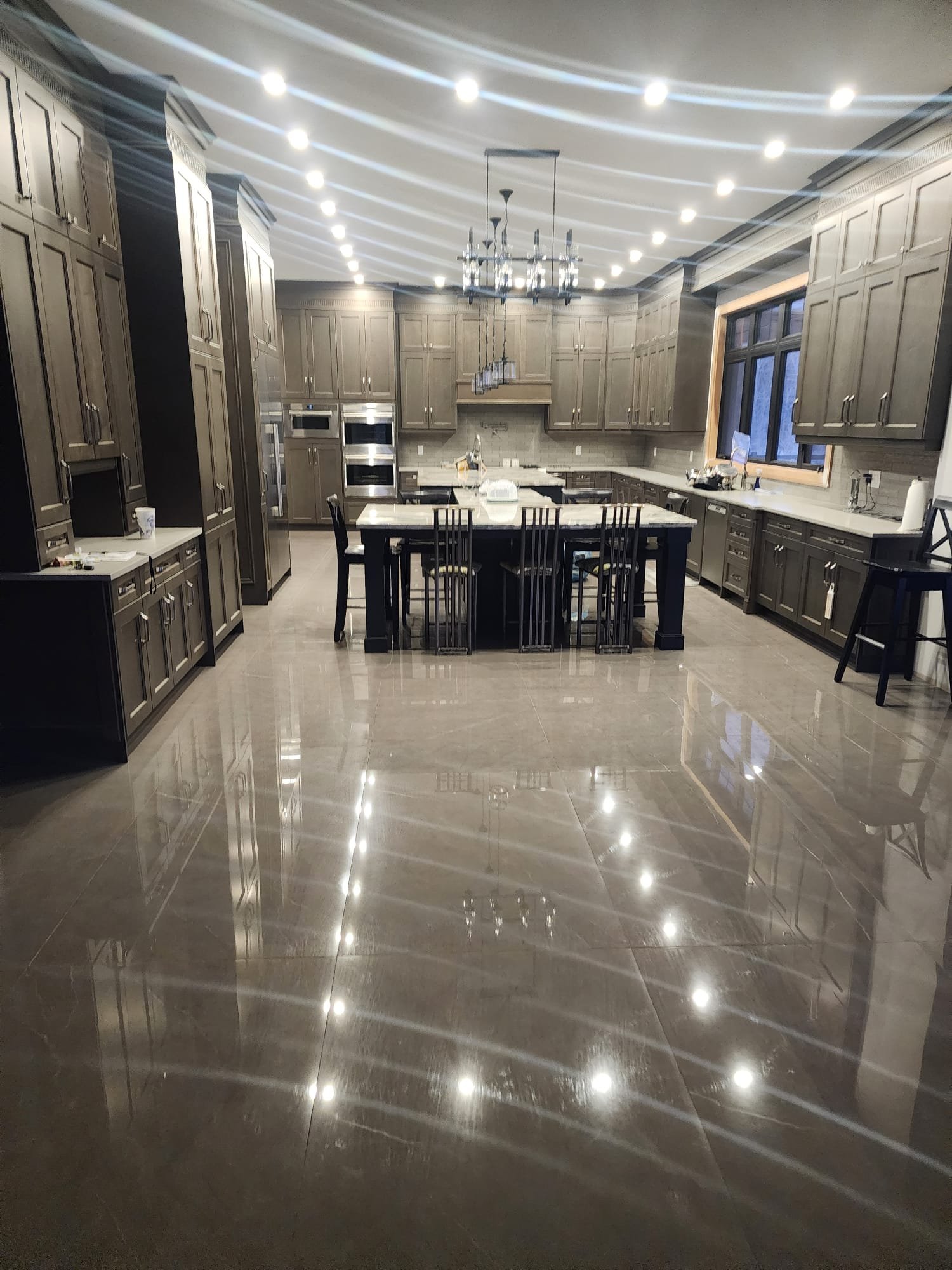 Completed luxury kitchen with custom cabinetry, large island and refined interior finishes