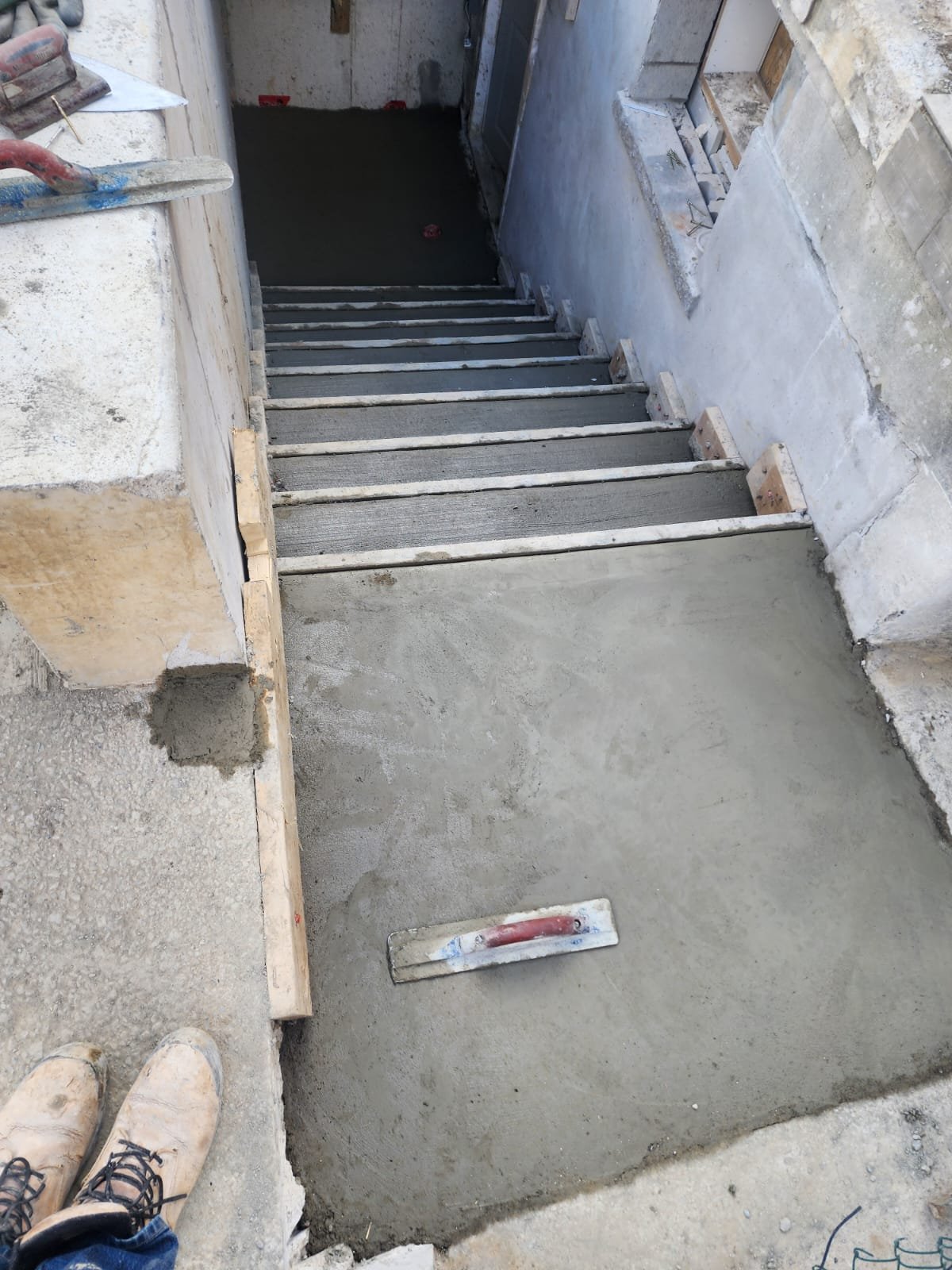 Concrete stair access to a lower-level entrance under construction
