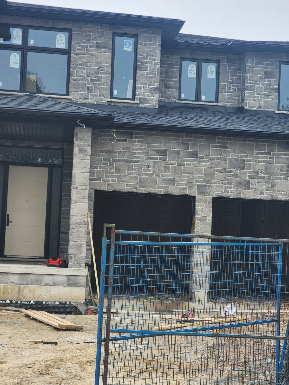 Townhome-style stone facade during exterior construction progress