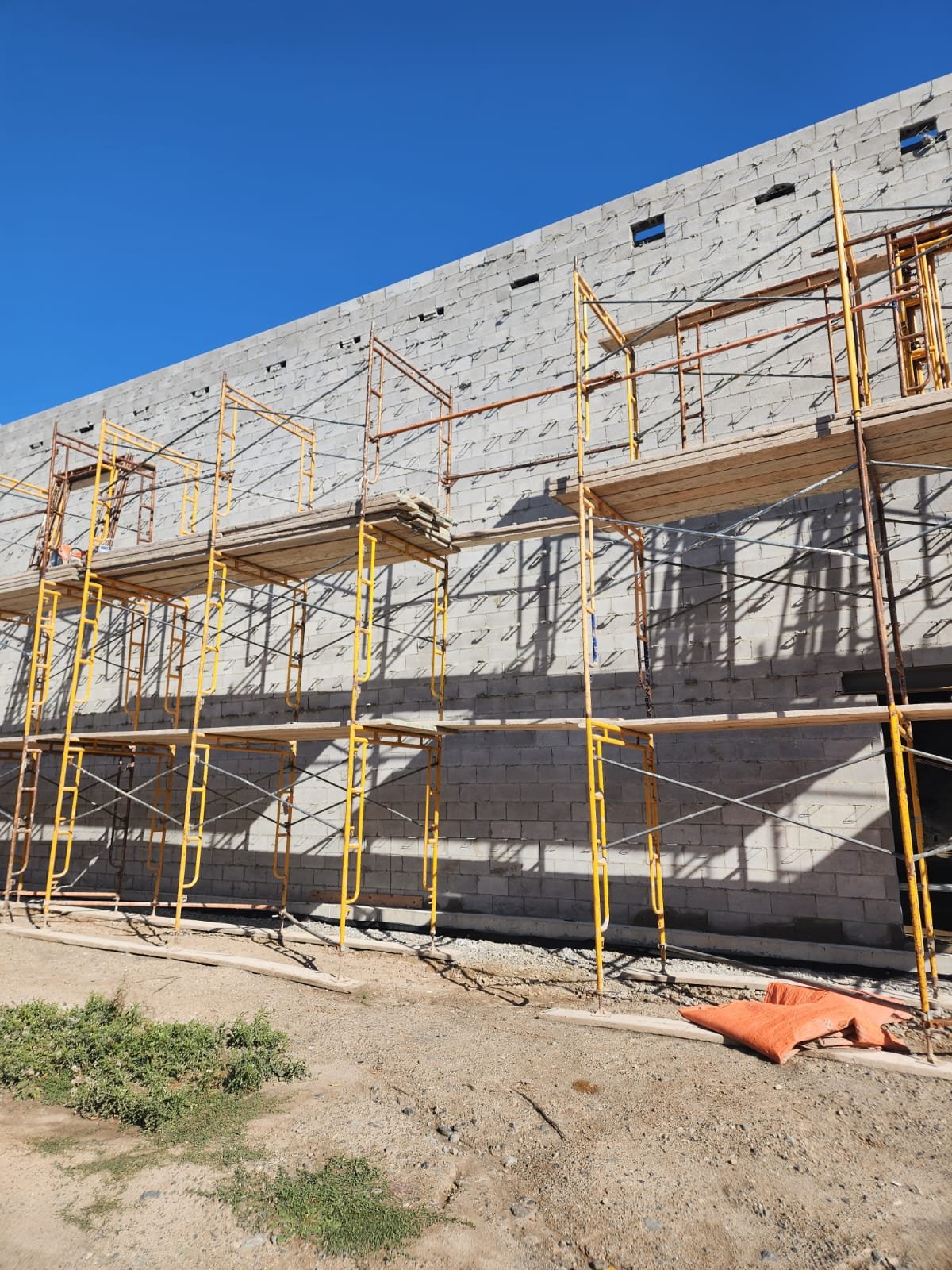 Commercial masonry wall under construction with scaffolding on site