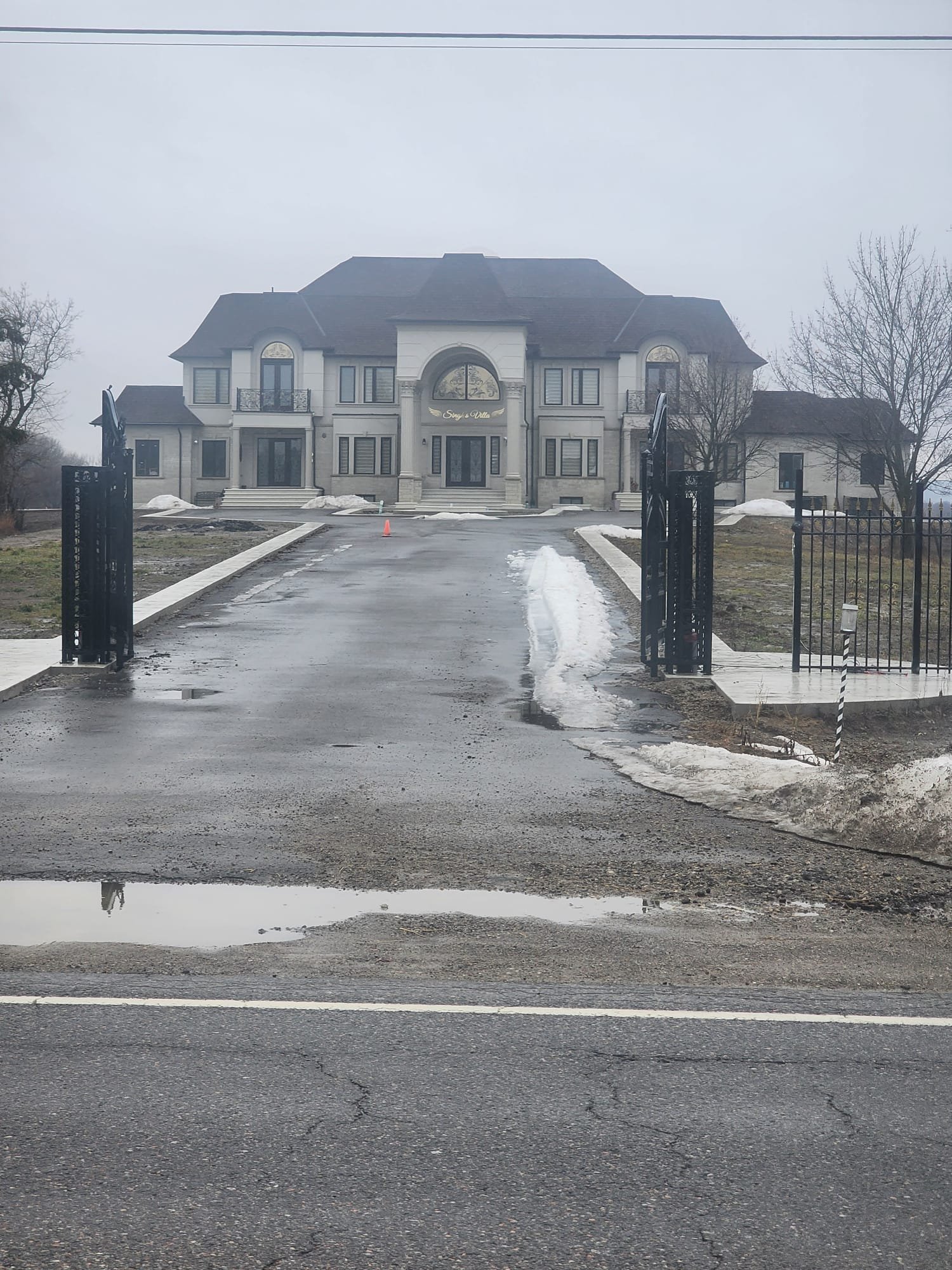 Front view of a large estate-style residence with finished exterior