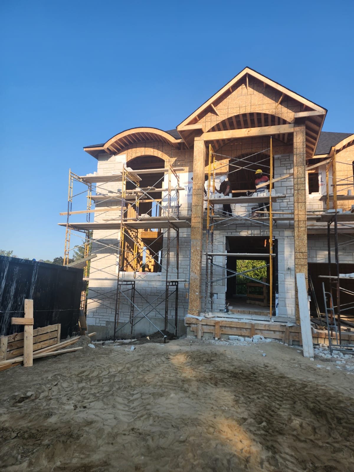 Luxury home shell under construction with scaffolding at the exterior